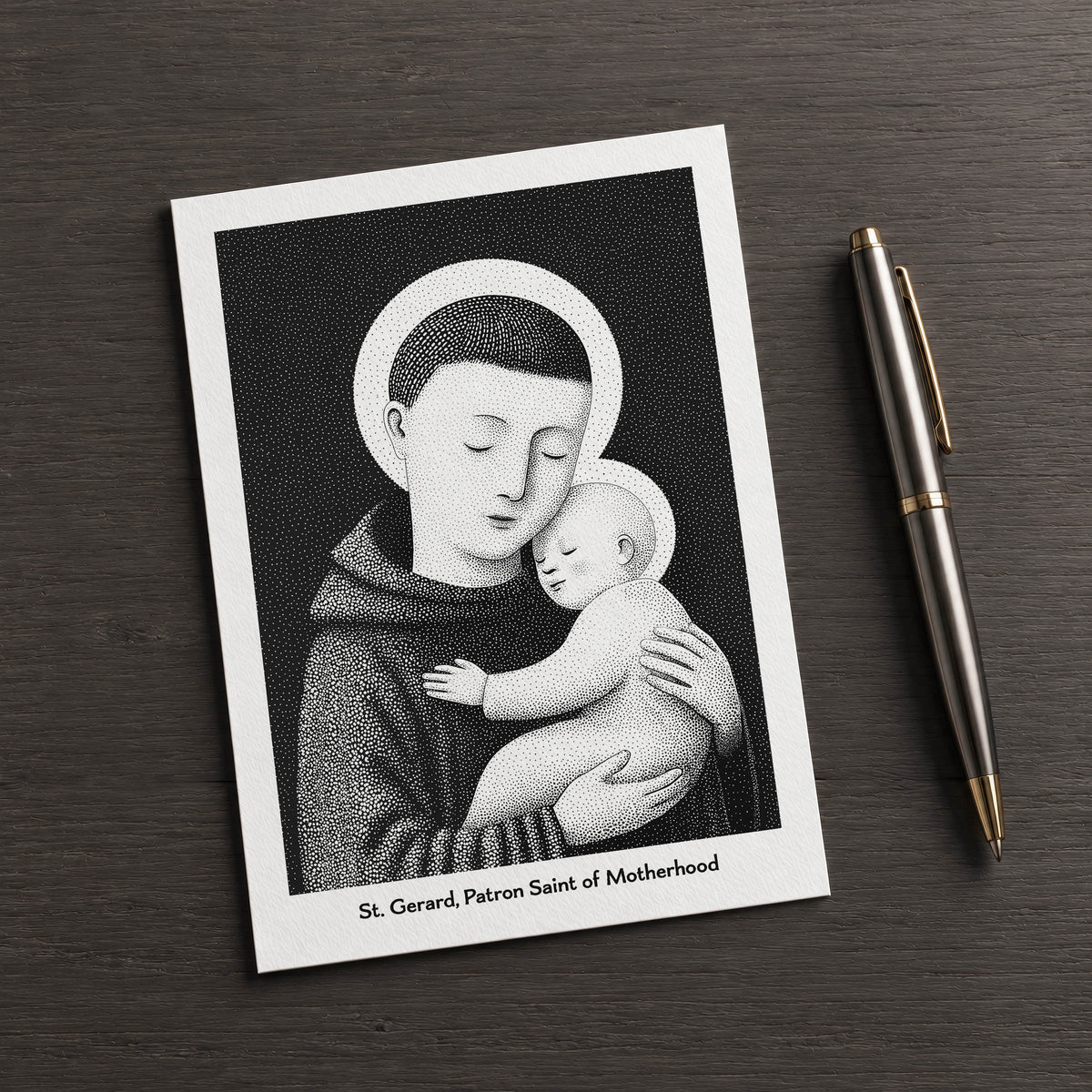 Black St Gerard Majella card on a dark table beside a pen