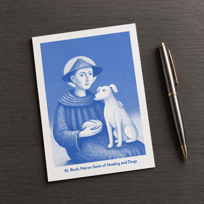 Blue St Roch card on a dark table beside a pen