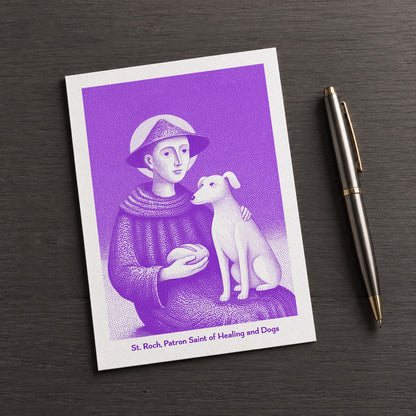 Purple St Roch card on a dark table beside a pen