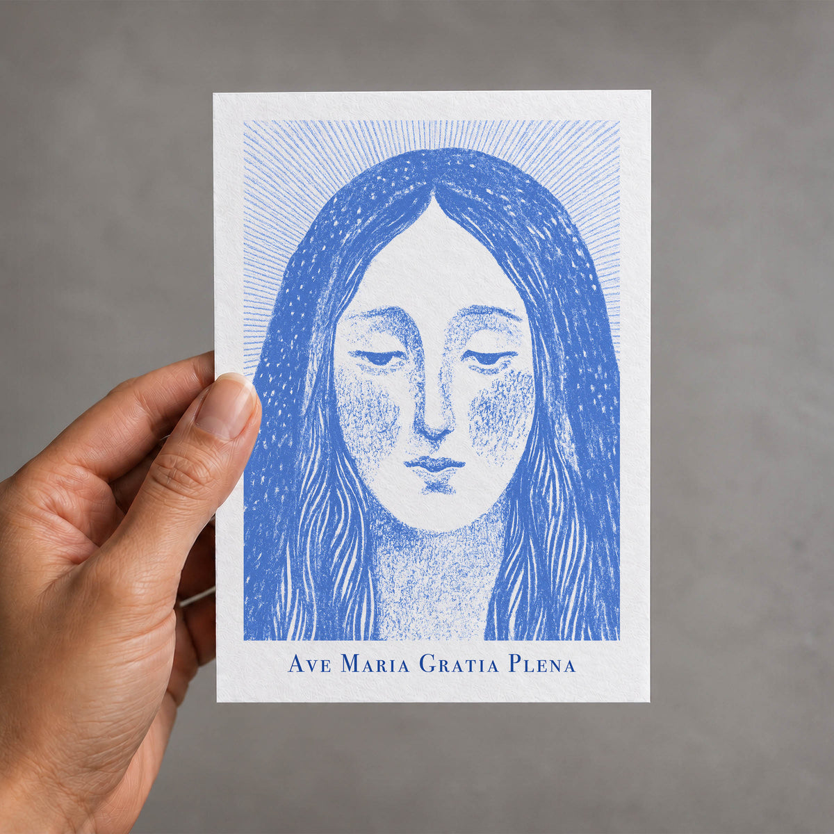 Blue Virgin Mary card held in a hand