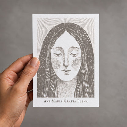 Brown Virgin Mary card held in a hand
