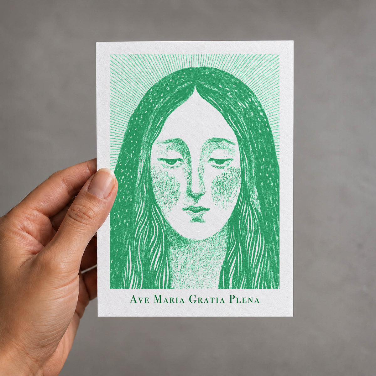 Green Virgin Mary card held in a hand