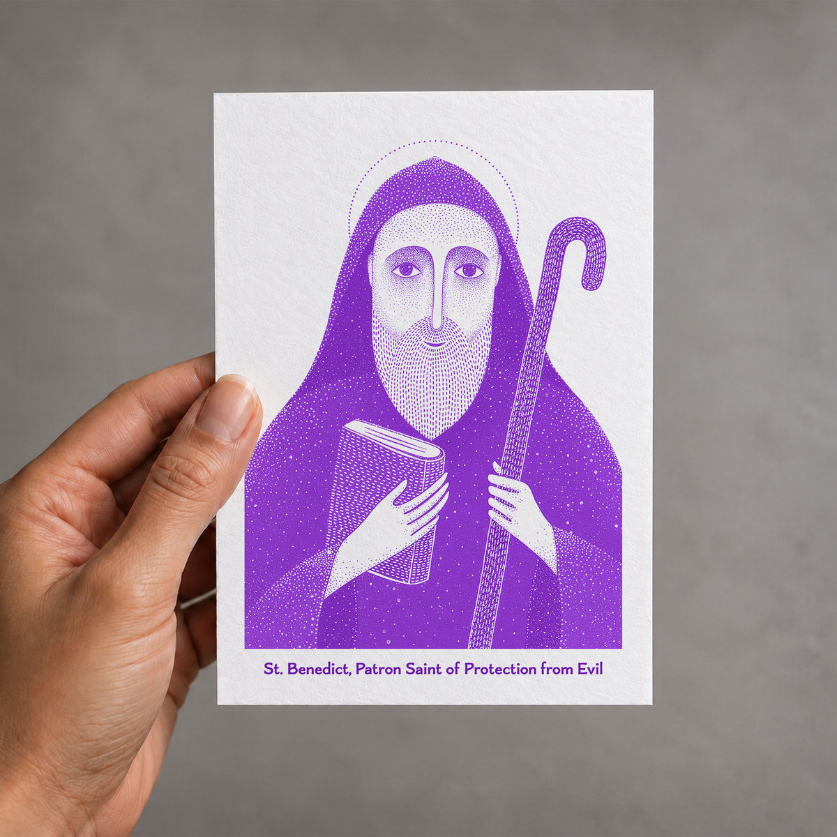 Purple St Benedict card held in a hand