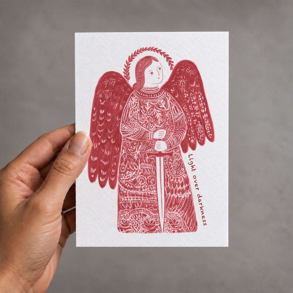 Red St Michael the Archangel card held in a hand