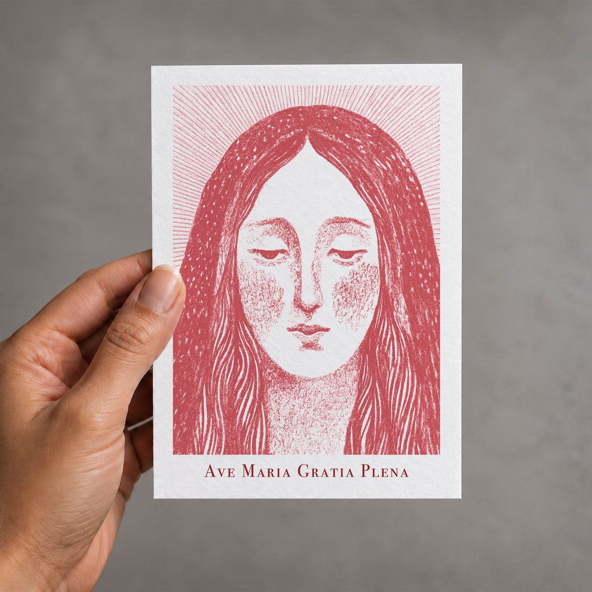 Red Virgin Mary card held in a hand