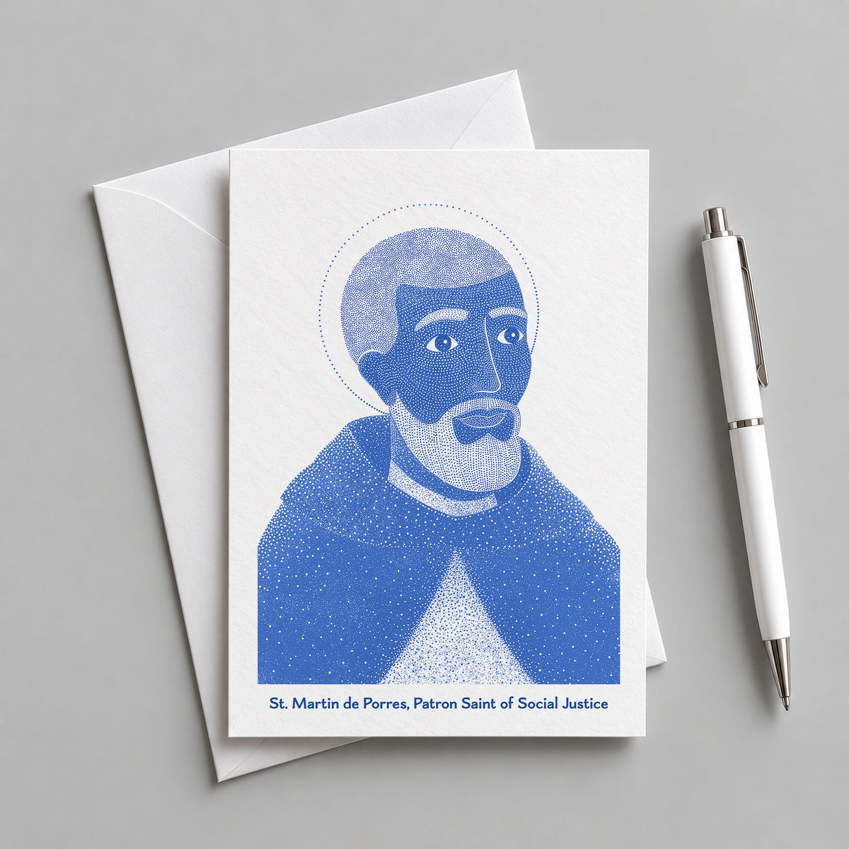 Blue St Martin de Porres card with an envelope and pen