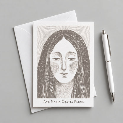 Brown Virgin Mary card with an envelope and pen