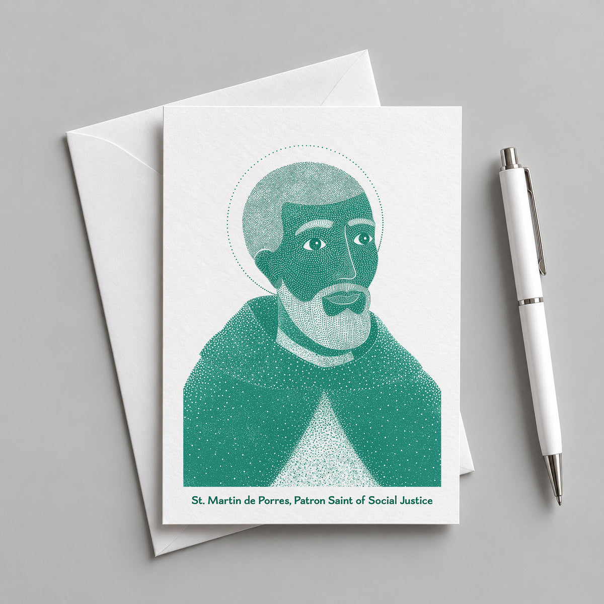 Teal St Martin de Porres card with an envelope and pen