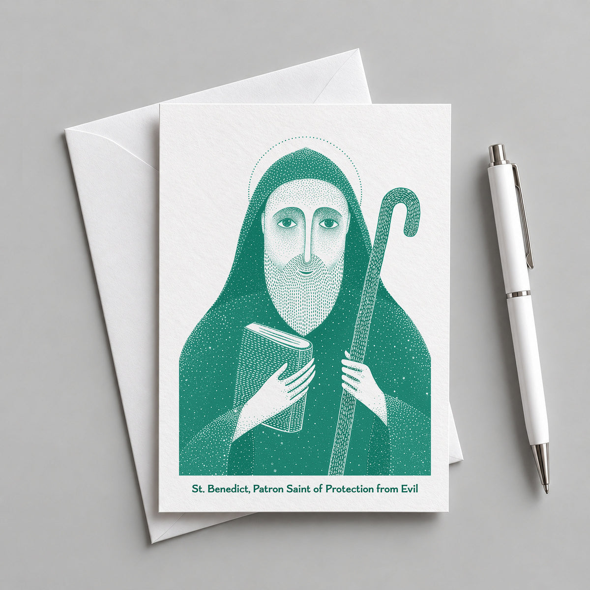 Teal St Benedict card with an envelope and pen